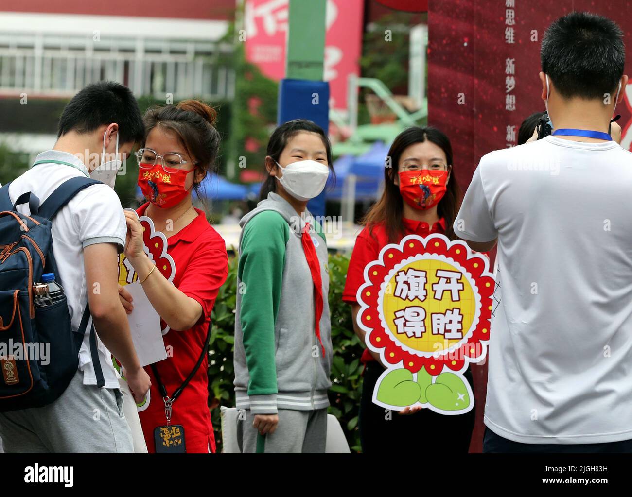 Shanghai. 11th luglio 2022. Gli studenti e i loro insegnanti che tengono consigli con i loro migliori desideri posano per le foto in un sito di esame del 2022 esame di ingresso delle scuole superiori nel distretto di Minhang di Shanghai della Cina orientale, il 11 luglio 2022. Lunedì è iniziato l'esame di ingresso delle scuole superiori di 2022 anni a Shanghai. Gli esami di ingresso della città per le scuole superiori sono stati rinviati per circa un mese a causa della rinascita delle infezioni COVID-19. Credit: Liu Ying/Xinhua/Alamy Live News Foto Stock