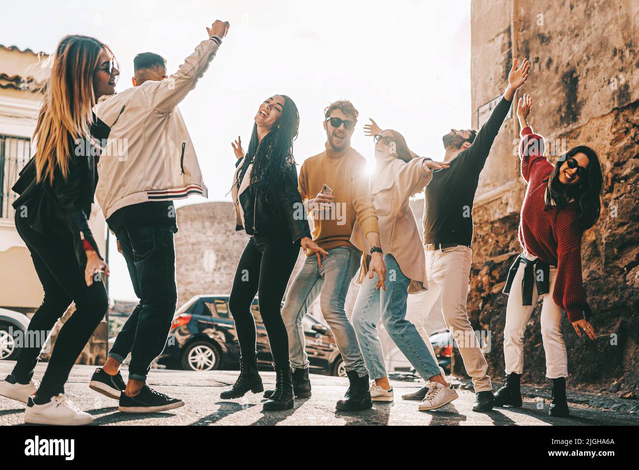 gruppo di amici felici multietnici divertirsi nel weekend ballando insieme per le strade - divertente multirazziale concetto di stile di vita dei giovani Foto Stock