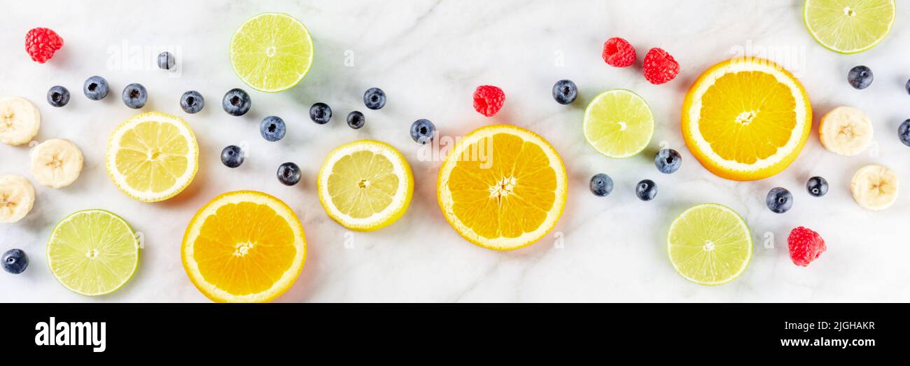 Panorama fresco di cibo estivo, ingredienti di Macedonia di frutta, girato dall'alto su sfondo di marmo bianco Foto Stock