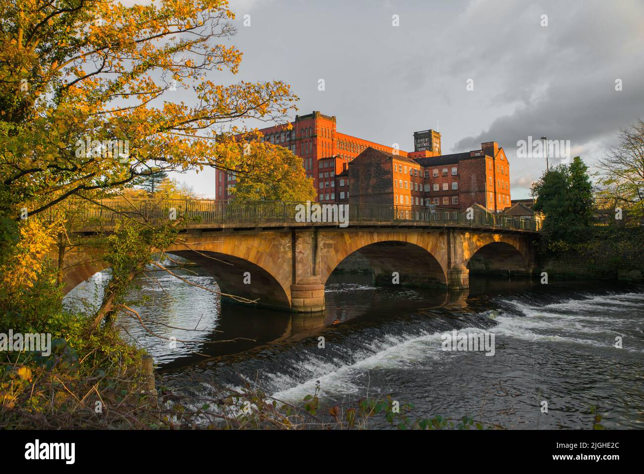 Belper Bridge sul fiume Derwent con North Mill e il più grande East Mill dietro. Belper, Derbyshire, Regno Unito Foto Stock