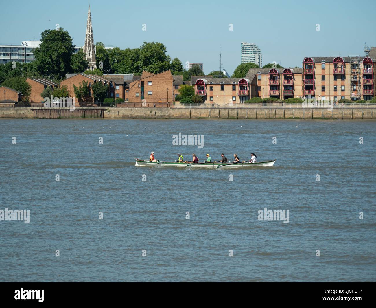 Rowers sul Tamigi a Greenwich con Isle of Dogs in background, Londra SE10 UK Foto Stock