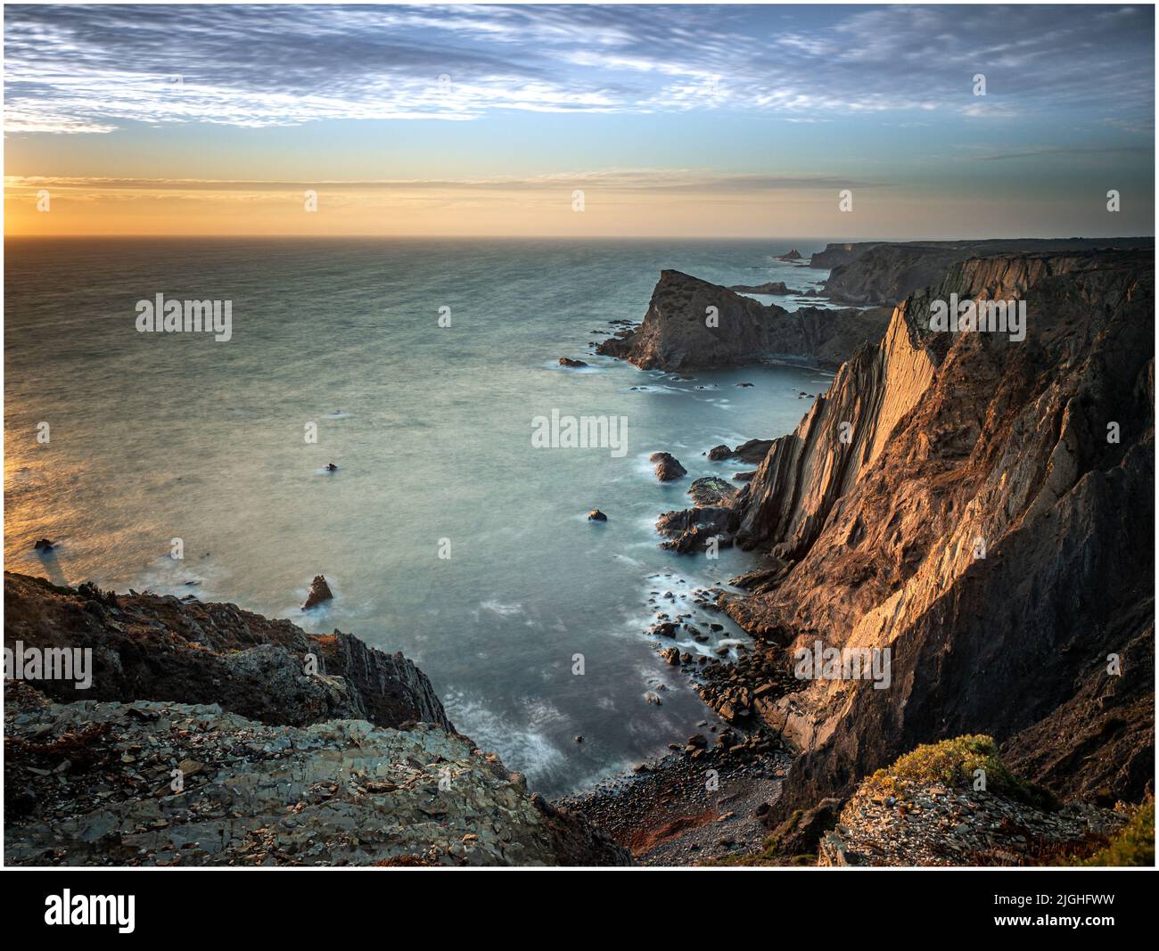 Gli ultimi raggi di luce illuminando la seacliffs a Arrifana sulla costa atlantica del Portogallo Foto Stock