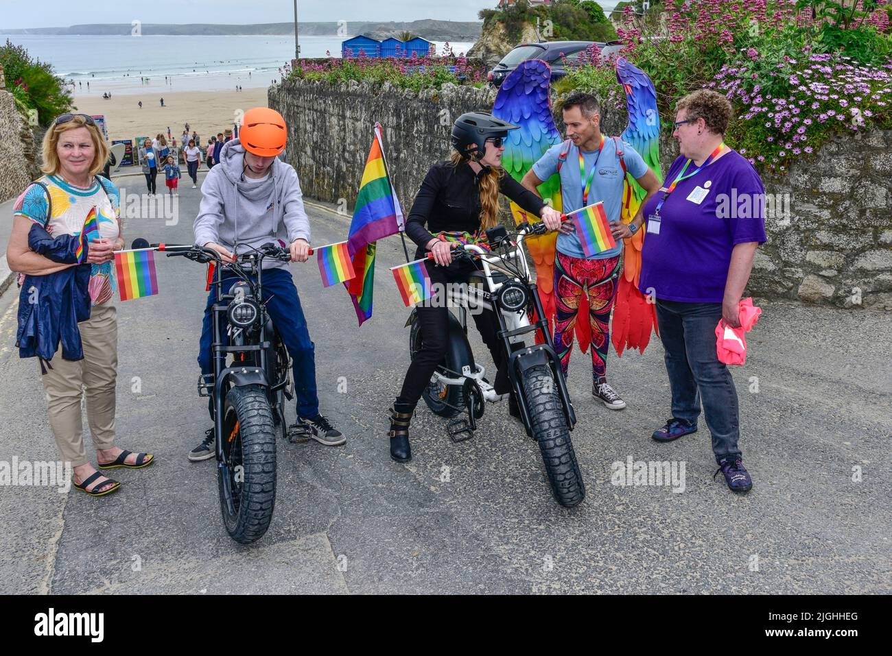 I piloti che usano biciclette elettriche Super 73 all'inizio della vivace e colorata Cornovaglia, sono orgogliosi della sfilata Pride nel centro di Newquay, nel Regno Unito. Foto Stock