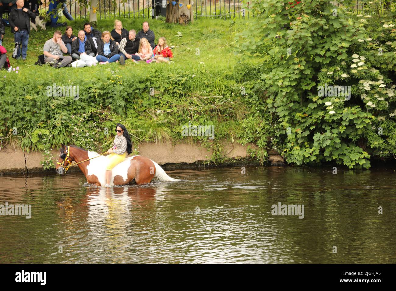 Una giovane donna che cavalca il suo cavallo attraverso il fiume Eden, Appleby Horse Fair, Appleby a Westmorland, Cumbria Foto Stock