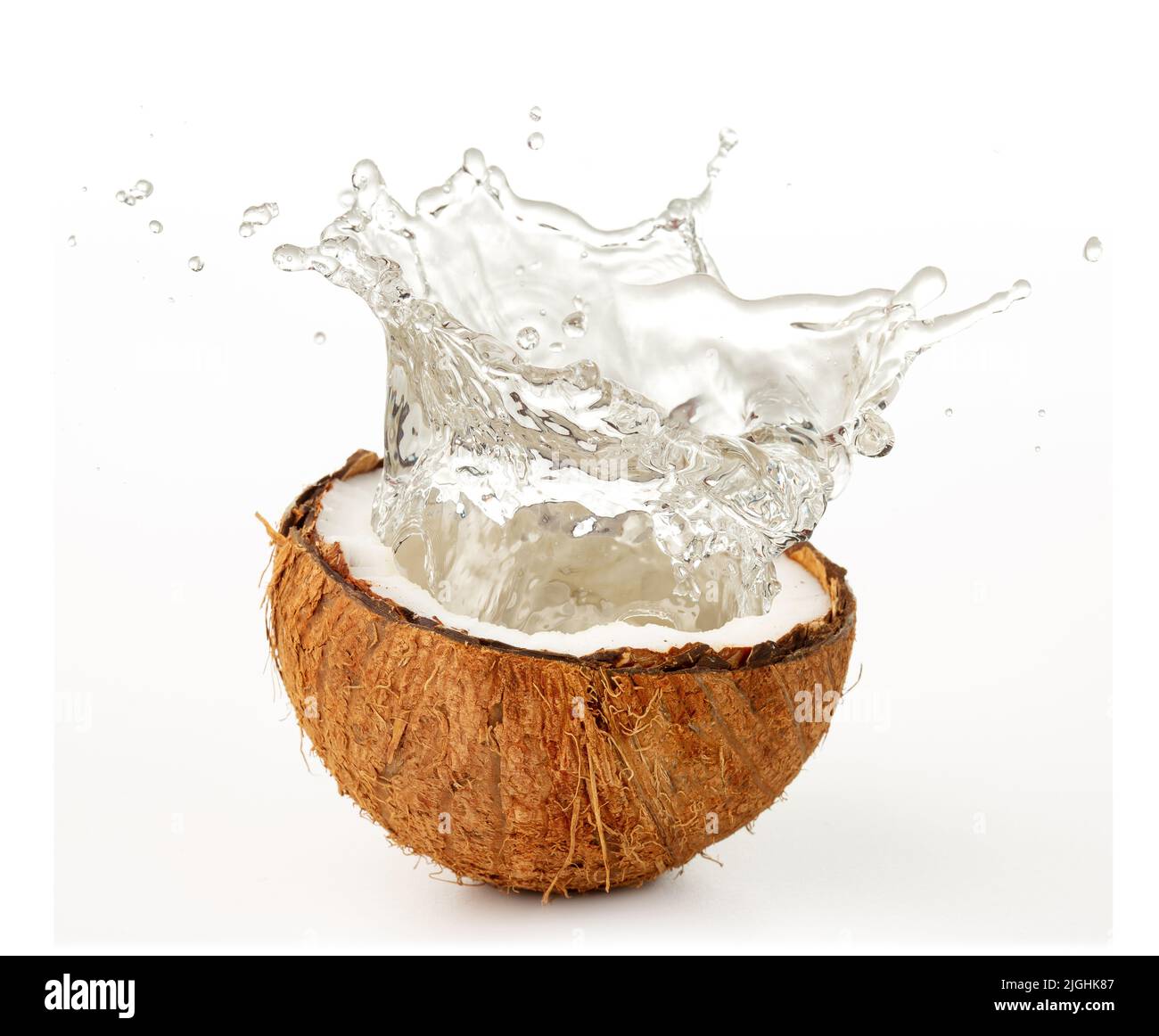 spruzzi d'acqua da una noce di cocco isolato su bianco Foto Stock