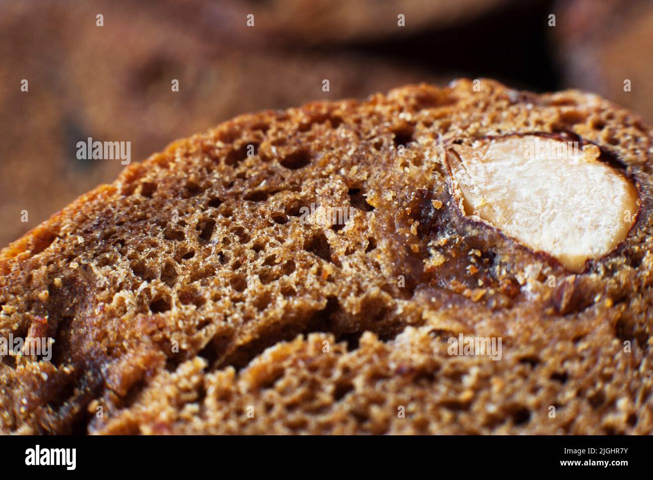 Fetta di pane di segale dolce con nocciole, sfocata Foto Stock