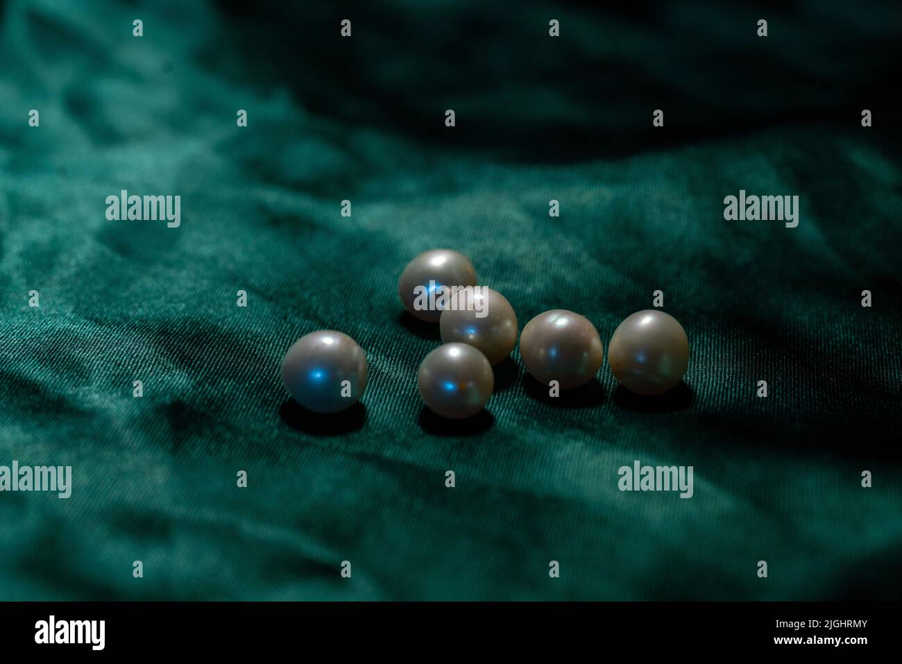 Palle di perle di fiume con un foro per il filo a su tessuto verde - circa 1 mm di diametro ю da India Maybre vera perla. Foto Stock