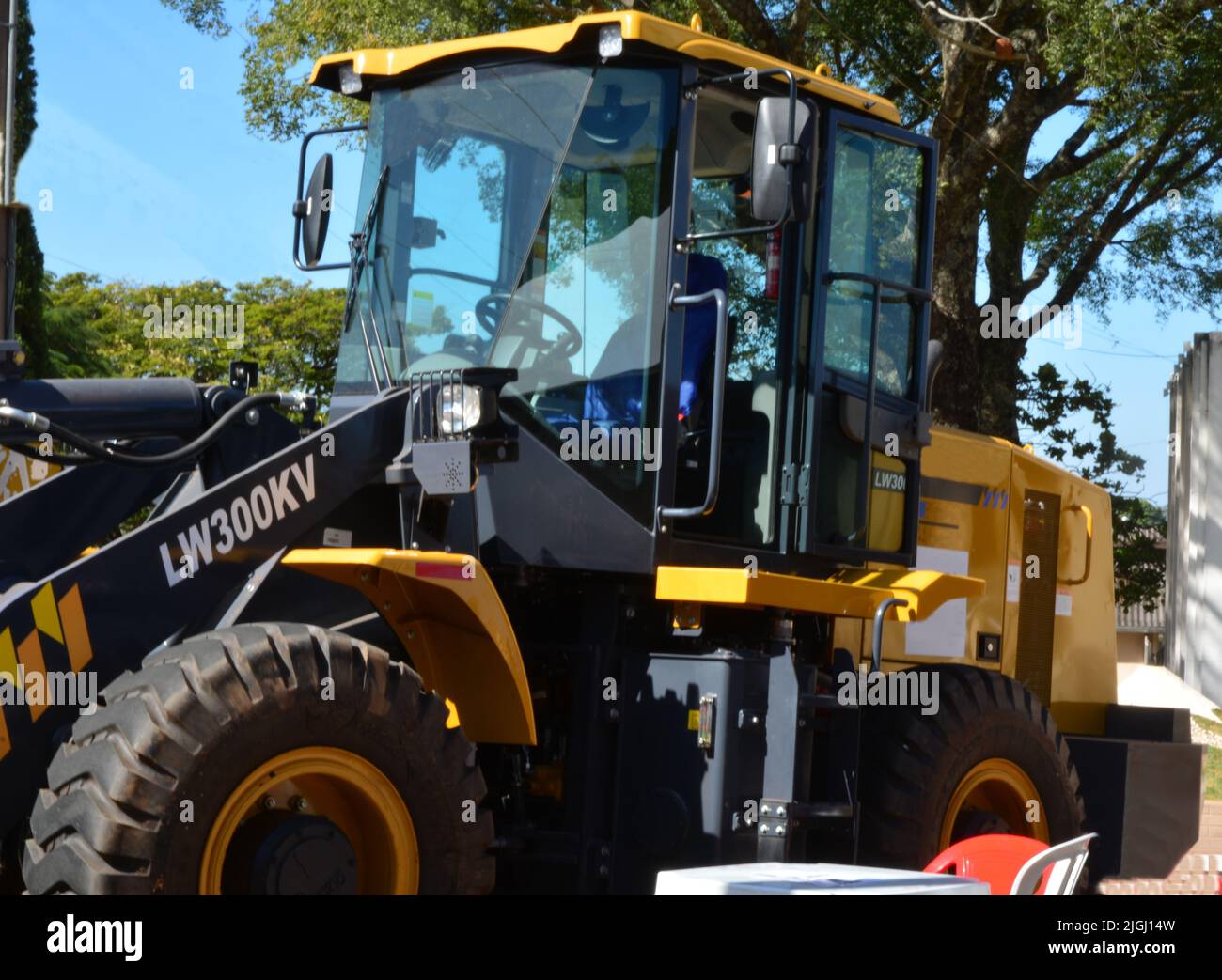 Trattore con pala gommata di colore giallo in mostra agricola in Brasile, Sud America in foto zoom, con sfondo sfocato. Foto Stock