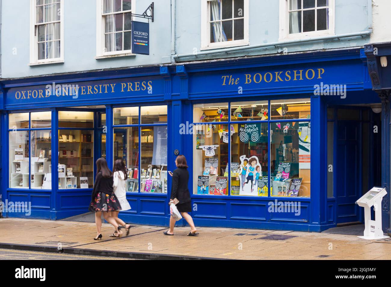 I turisti che camminano oltre l'Oxford University Press Bookshop ad High Street, Oxford, Oxfordshire UK nel mese di agosto in una giornata piovosa bagnata Foto Stock