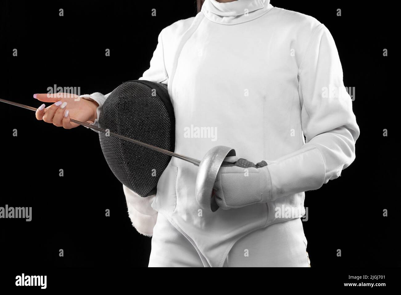 Closeup corpo del fencer femminile in costume di scherma bianco con maschera e pinza isolato su sfondo scuro. Sport, gioventù, attività, abilità, realizzazioni Foto Stock