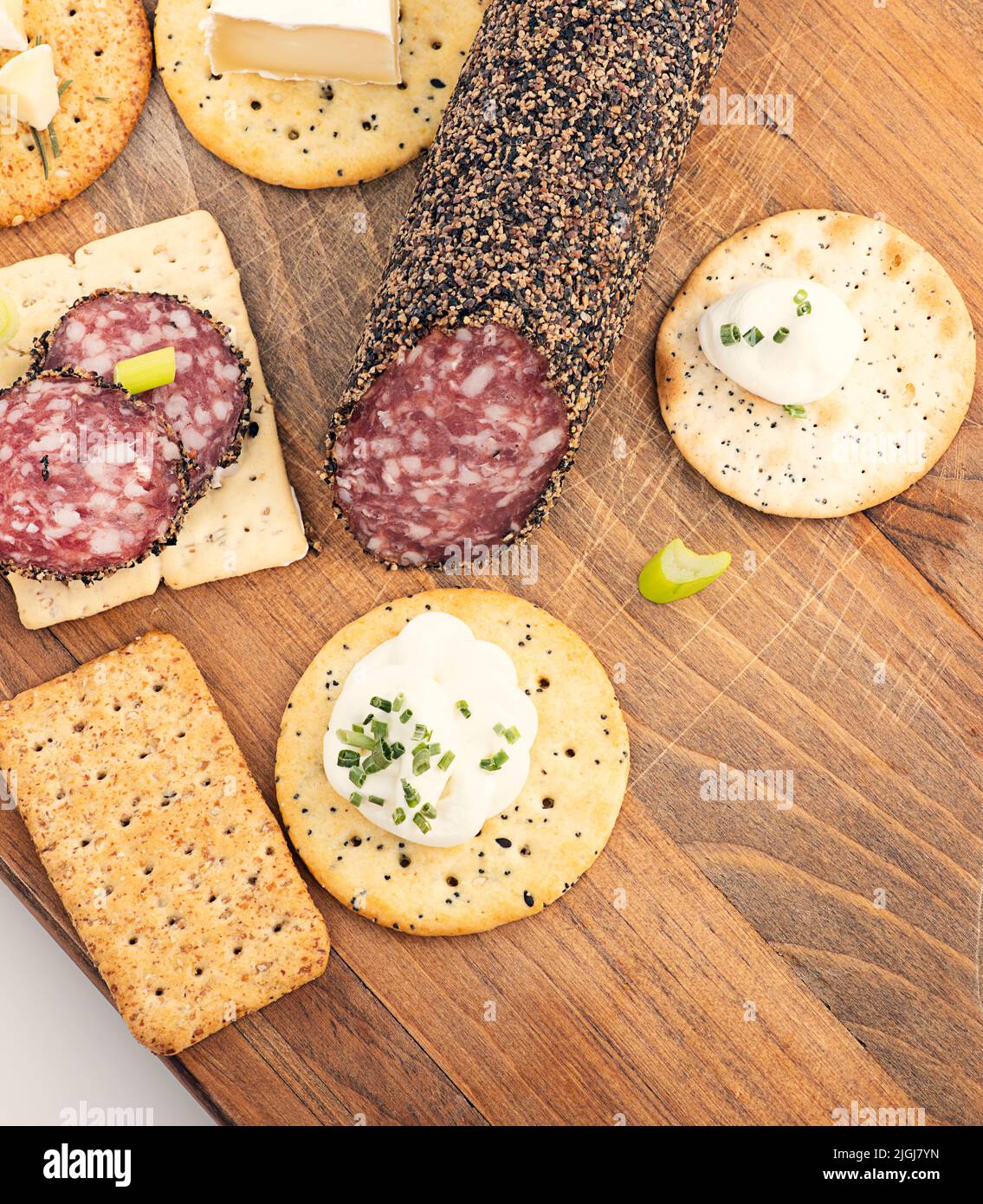 Cracker con salame, formaggio e salse sul tagliere Foto Stock