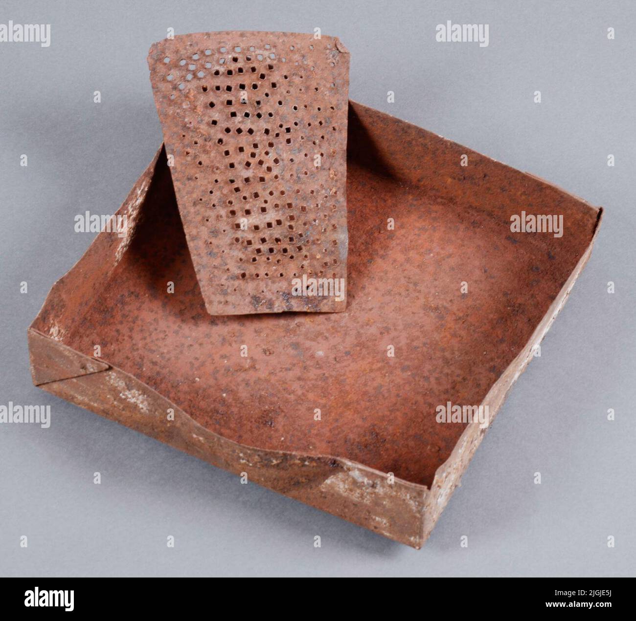 Rivjärn grattugia, e scatola di raccolta, di ferro. Rossastro colorato con gesso rosso per il loro uso come grattugia e scatola di raccolta per gesso rosso, come lavoro preliminare per lucidare il rame. Grattugia arcuata e ben utilizzata lunga 160 mm, larga 85-120 mm (rastremata verso l'estremità) e alta 20 mm. Buffy box 240x240 mm grande. Grattugia e scatola di raccolta Rehears con BLM 28810: 126; gesso rosso, che è usato nella lucidatura del rame. Gli oggetti facevano parte di un museo di rame a Branthalla, Torhamn sn., inviato da Thage Olsson su suo padre e nonno; Sven-Robert Olsson (1897-1963) e Ola Sven Olsson (1854-1 Foto Stock