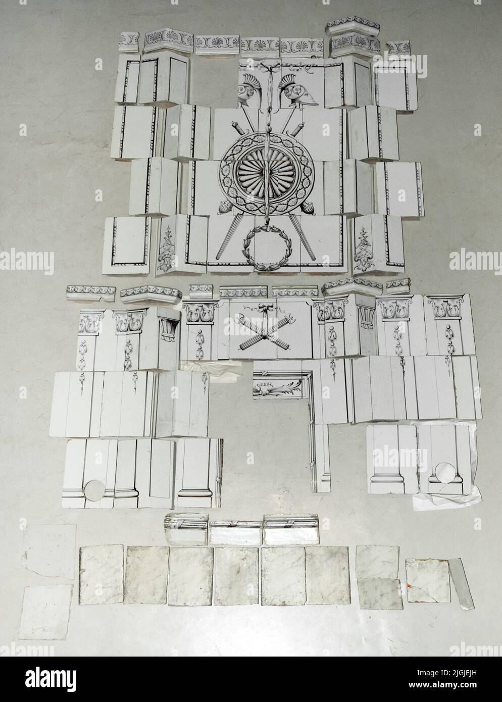 Stufa Kakelugn Tile, smaltata in bianco, con decorazioni in grigio marrone. Il forno è composto da: 9 tegole di foglie, a piedi con marmorizzazione di olio di lino vernice. 3 tegole di foglie, che probabilmente anche stato a piedi. nuoto di 3 piedi. 13 piastrelle d'angolo, con decor variabile. 38 tegole di foglie, una metà, alcune scolpite per l'apertura del camino. Decorazioni variabili su queste piastrelle in foglia; colonne, scudo, caschi etruschi, corona di magazzino e varie insenature. 7 Midsimpy. 15 trasmissione. 7 Krönsimskakel. Stelle marine 6, Karlskrona. Regalo 1955 del direttore Erik Mattelin, Nättraby. Foto Stock