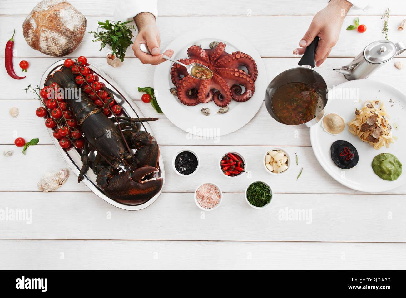 Chef versare polpo con salsa speciale, piatto Foto Stock