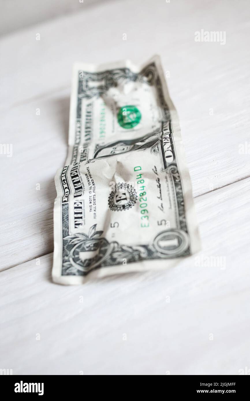Sminuzzati di un dollaro su sfondo bianco di legno Foto Stock