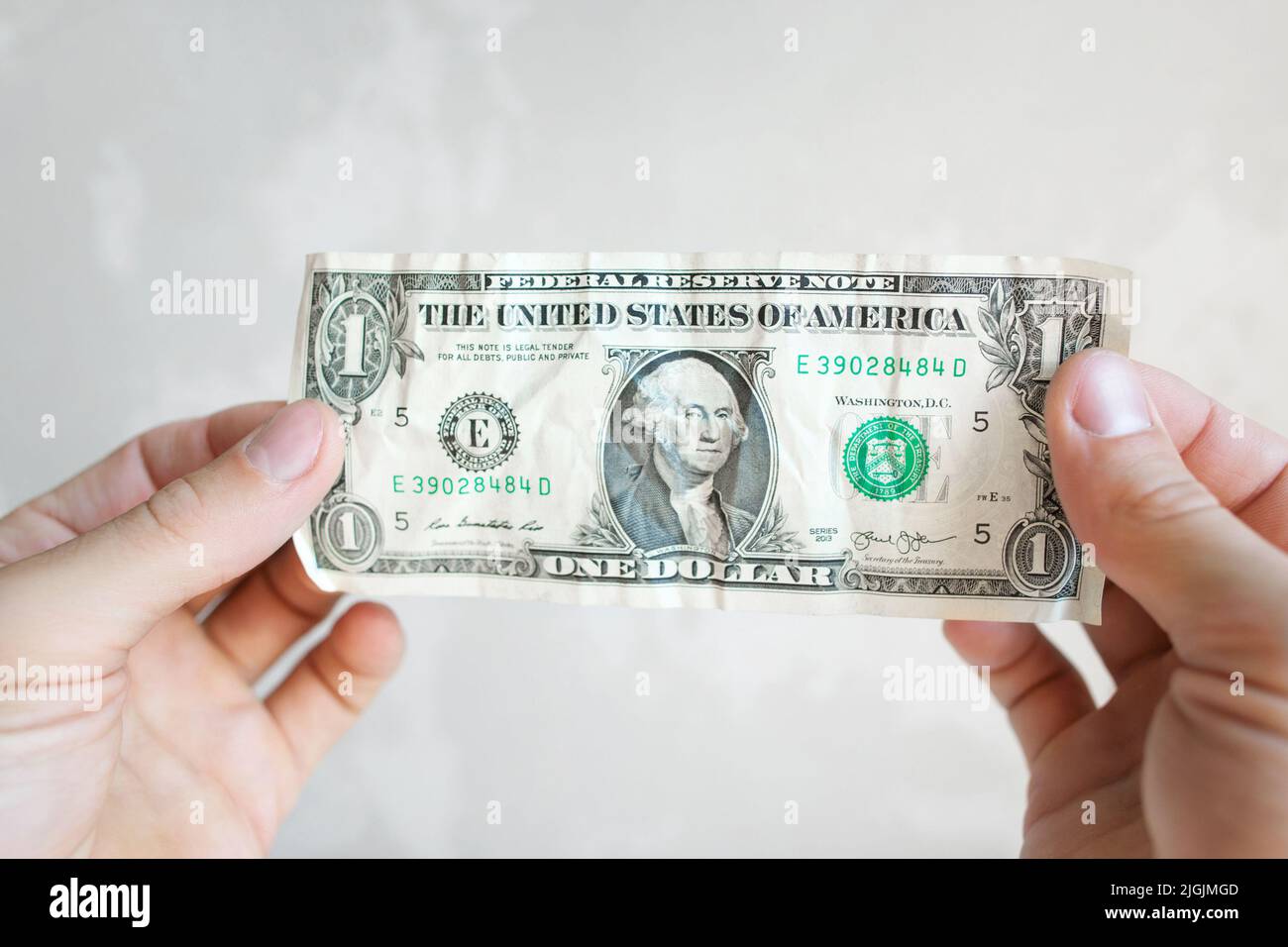 Una banconota da dollaro in mani maschili Foto Stock