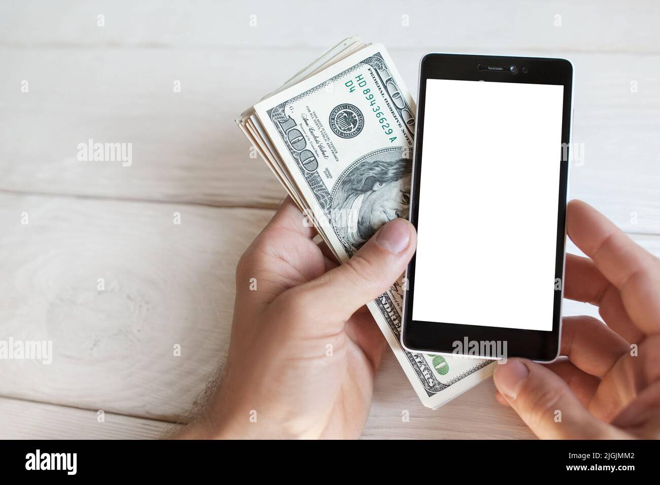 Mano maschile con smartphone e contanti americani, mokup Foto Stock