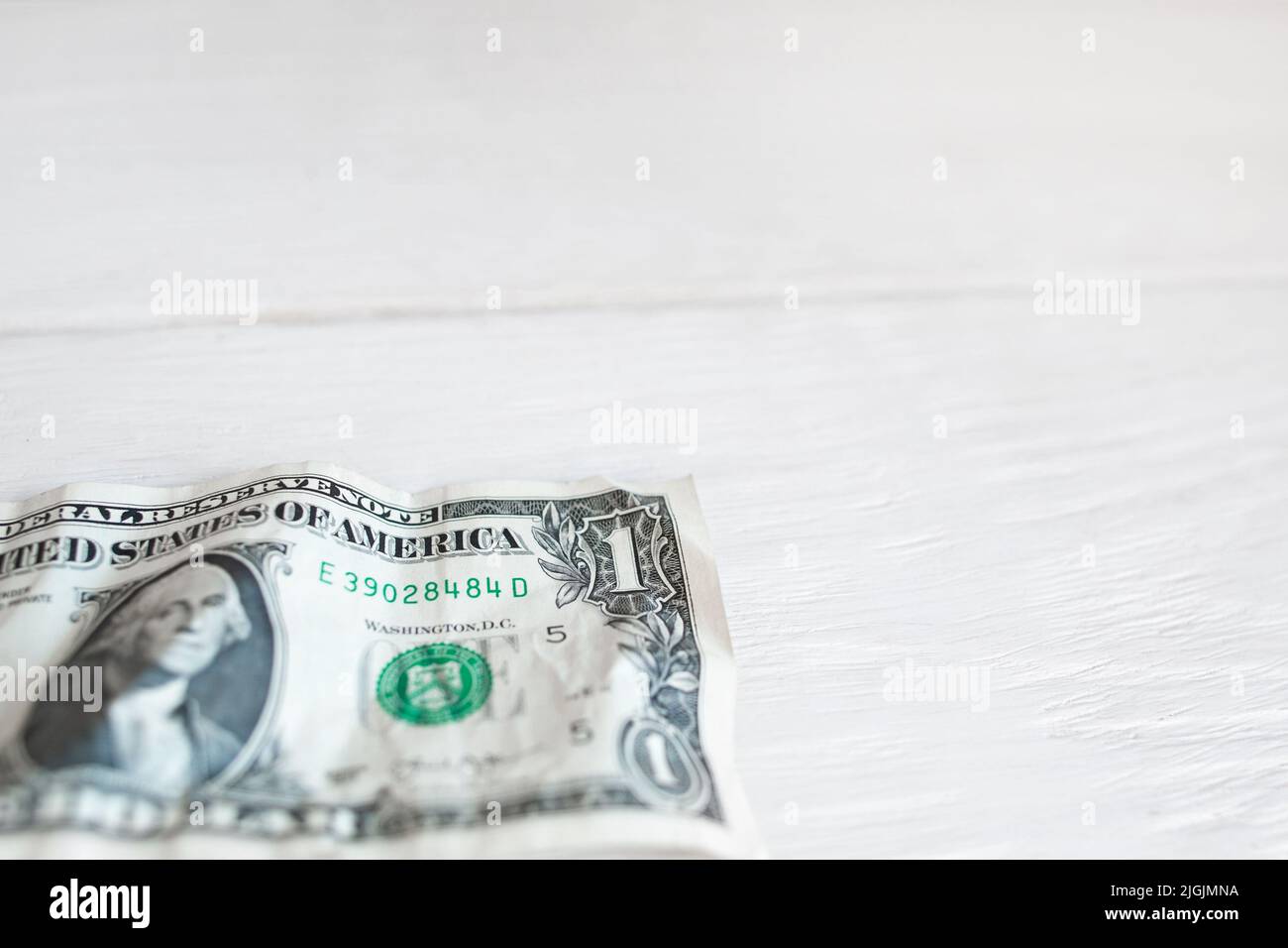 Un dollaro su sfondo bianco di legno, spazio libero Foto Stock