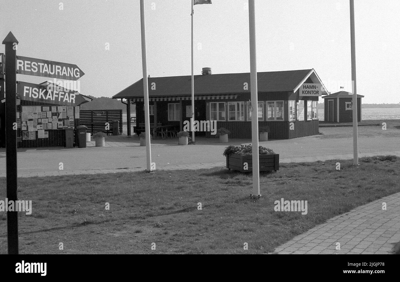 L'ufficio del porto di Hamn nel porto di Hällevik e il cartello di rinvio per Hennings Rökeri e il ristorante di pesca di Dagmar. Foto Stock