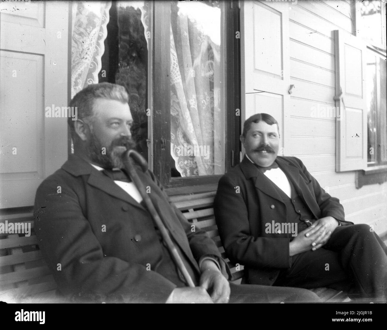 Uomo due uomini siedono su una panca. Foto Stock