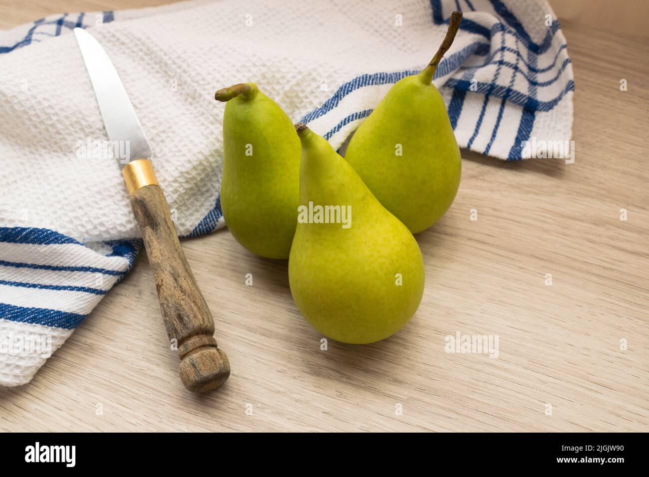 tre pere organiche con un coltello e un tovagliolo Foto Stock