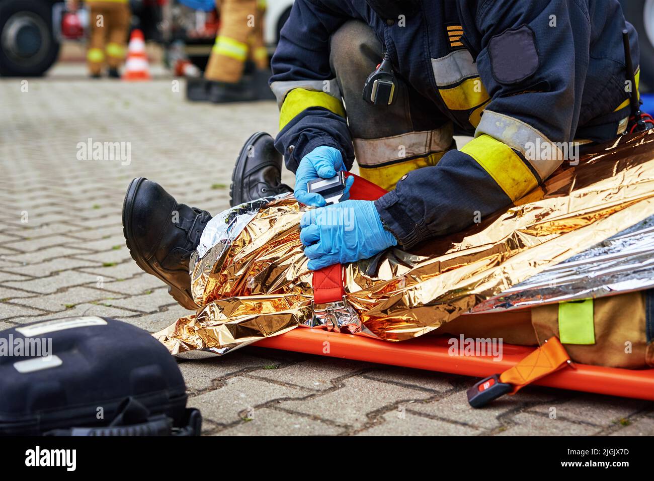 I soccorritori forniscono il primo soccorso alla vittima durante un incidente stradale. La persona ferita nell'incidente è sdraiata sulla strada Foto Stock