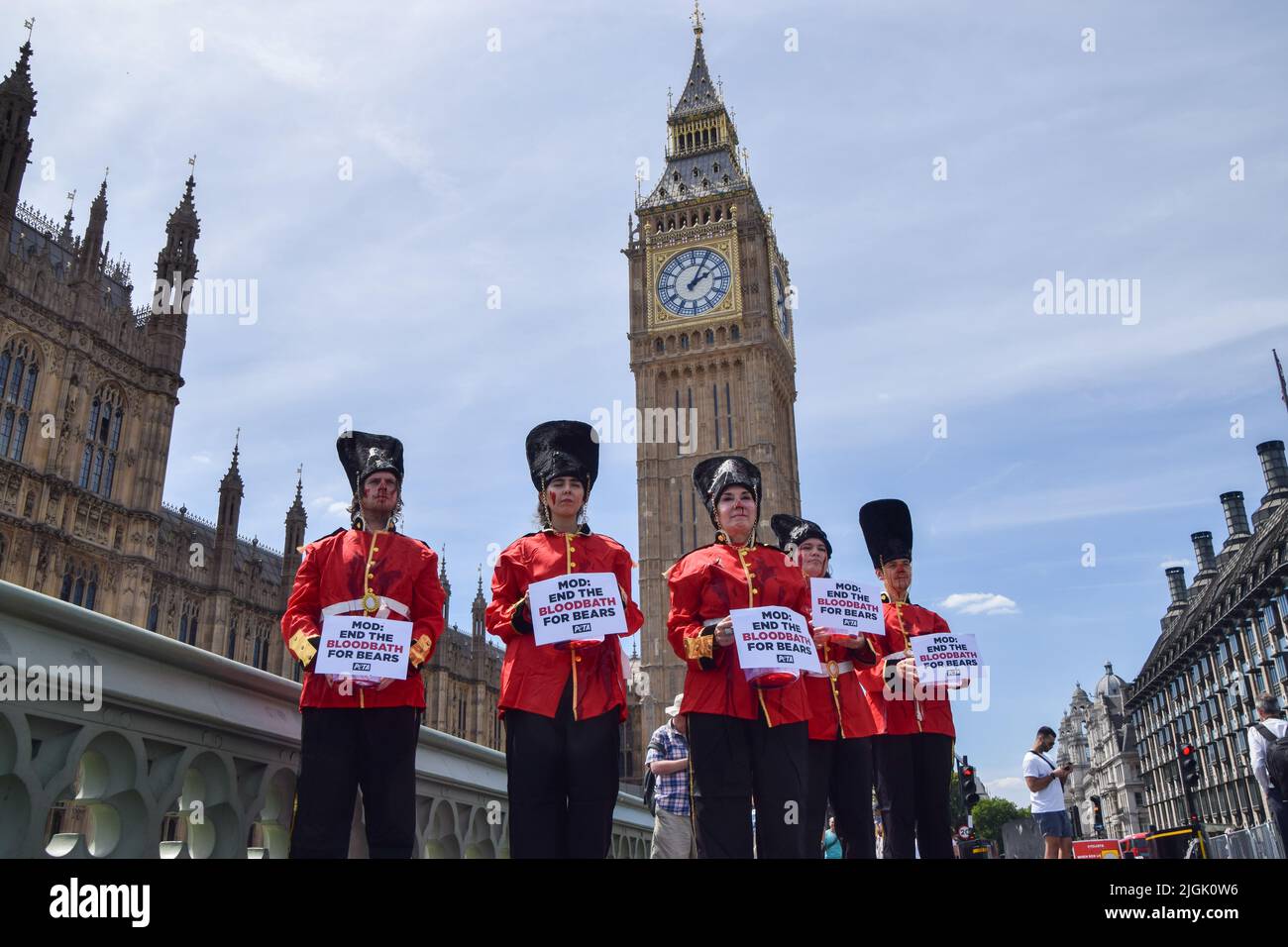 Londra, Inghilterra, Regno Unito. 11th luglio 2022. Gli attivisti DI PETA che indossavano i costumi della Queen's Guards, ricoperti di sangue falso e in piedi su Union Jacks macchiati di sangue, hanno organizzato una protesta contro l'uso di pelli di orso nei cappucci della Queen's Guards sul Ponte di Westminster fuori dal Parlamento. Attualmente, il Ministero della Difesa utilizza la vera pelliccia di orso per fare le calotte, e ci vuole un orso per fare solo una testa. PETA ha contribuito a sviluppare un'alternativa adatta alla pelliccia sintetica, che il MOD ha finora rifiutato di utilizzare. (Credit Image: © Vuk Valcic/ZUMA Press Wire) Foto Stock