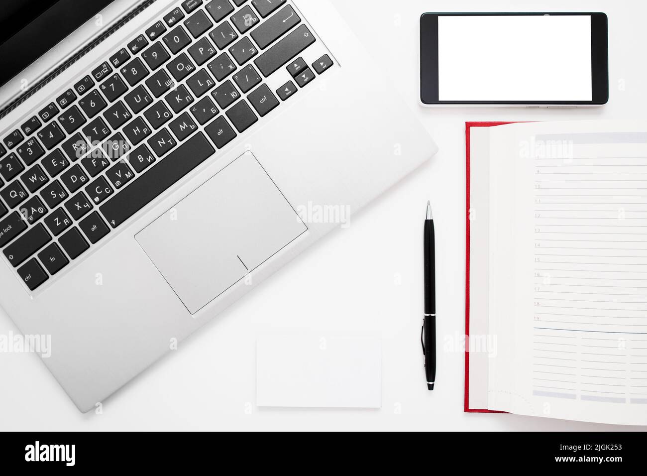 Scrivania bianca con notebook, smartphone e notebook Foto Stock