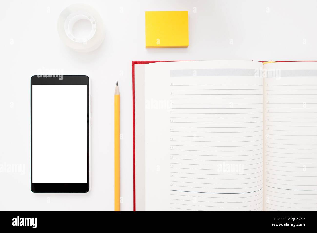 Smartphone, notebook, matita e adesivi a disposizione piatta Foto Stock