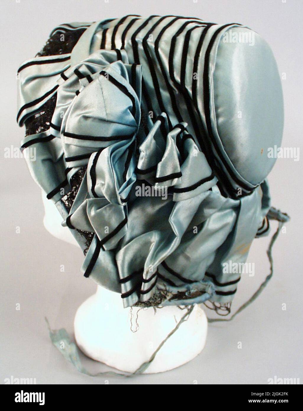 Kapotthatt cappello da capitolo di seta azzurro. Decorazioni in nero, strette fasce di velluto e pizzo. Rosetta su entrambi i lati. Questi sono fissati con i perni dei pulsanti. Parte posteriore Bavolet. 1/2 rivestimento di seta verde punteggiato. Cornice di Spatrius, Tarlatan, Tyll e Karkas. Parti a sinistra delle bande del mento. Cinghia per il mento blu chiaro (20 x 215 mm). 250 x 230 mm.1800s metà successiva. Kapotthatten venne dopo Bathytt nel 1860s. Foto Stock