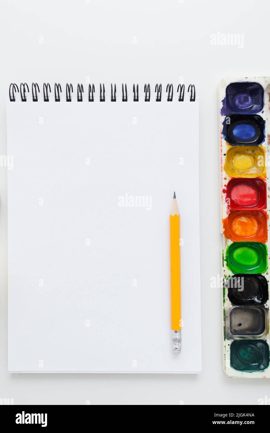 Notebook vuoto con matita e tavolozza di acquerelli Foto Stock