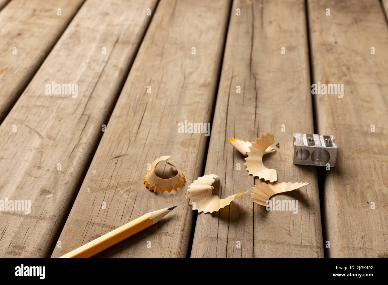 Immagine di matita, affilatrice e peelings su sfondo di legno Foto Stock