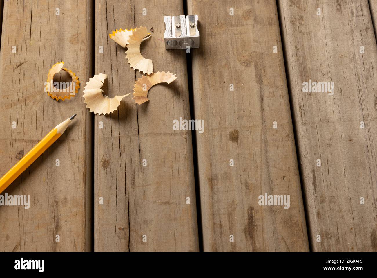 Immagine di matita, affilatrice e peelings su sfondo di legno Foto Stock