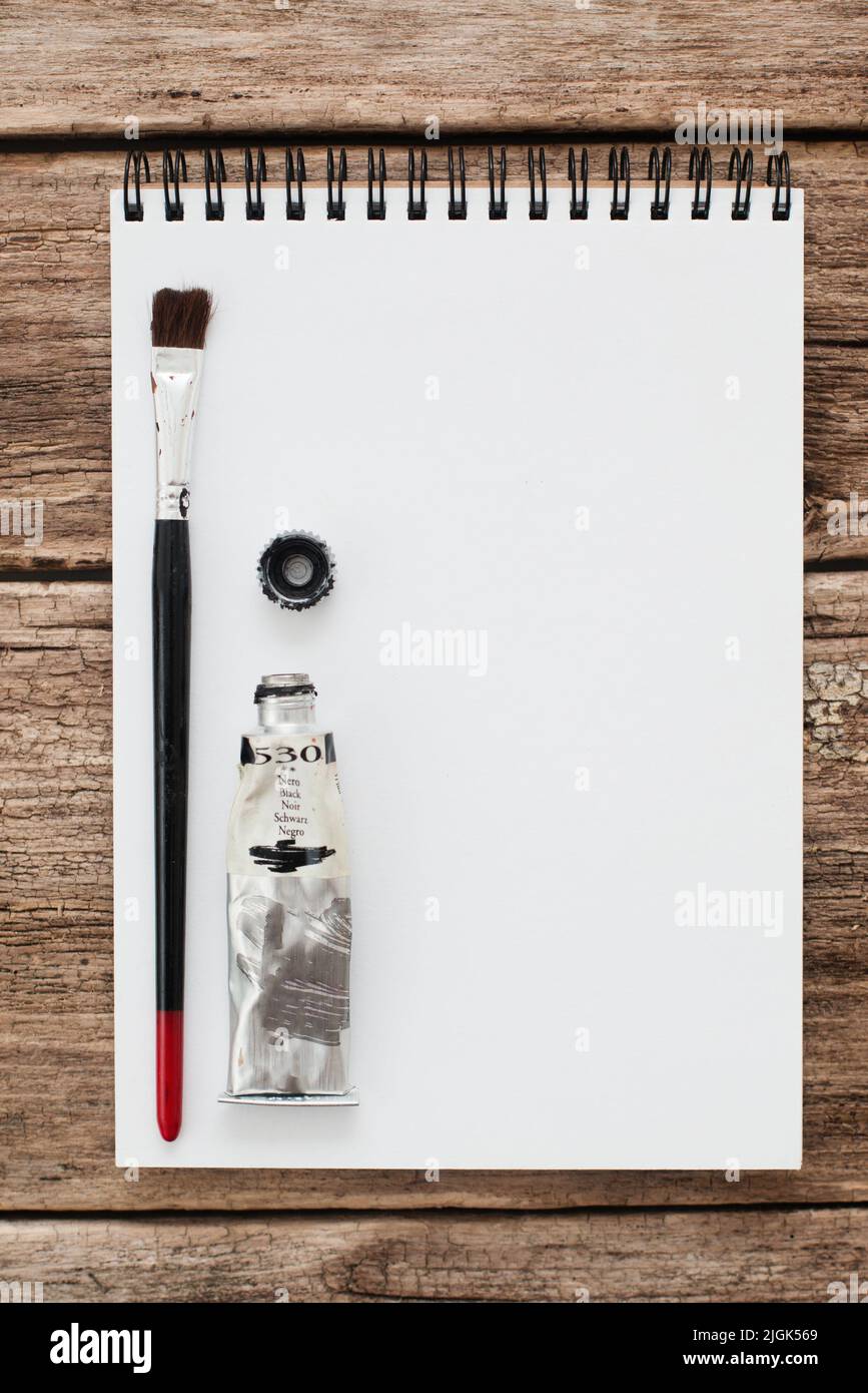 Libro di schizzo vuoto con vernice nera e mockup pennello Foto Stock