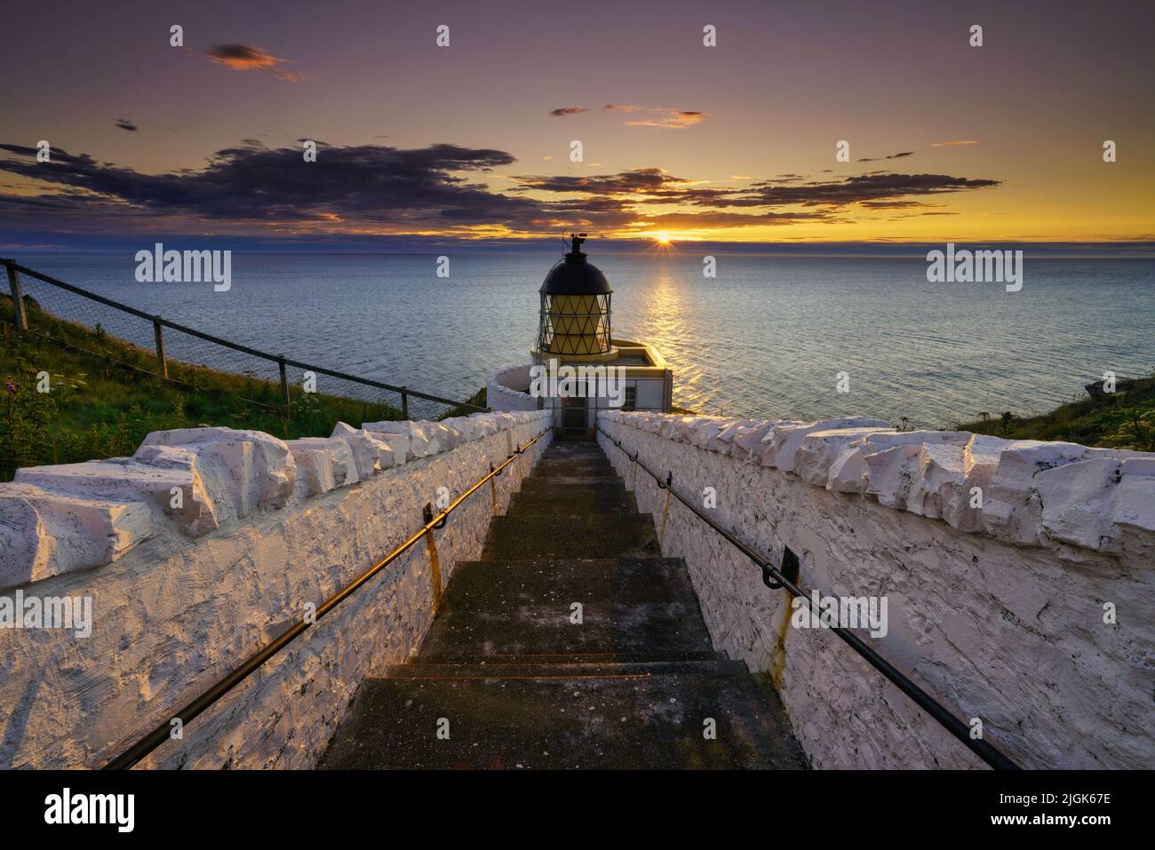 Faro di St Abbs all'alba con luce d'ora dorata. Situato nel Berwickshire, Scottish Borders, Scozia. Foto Stock