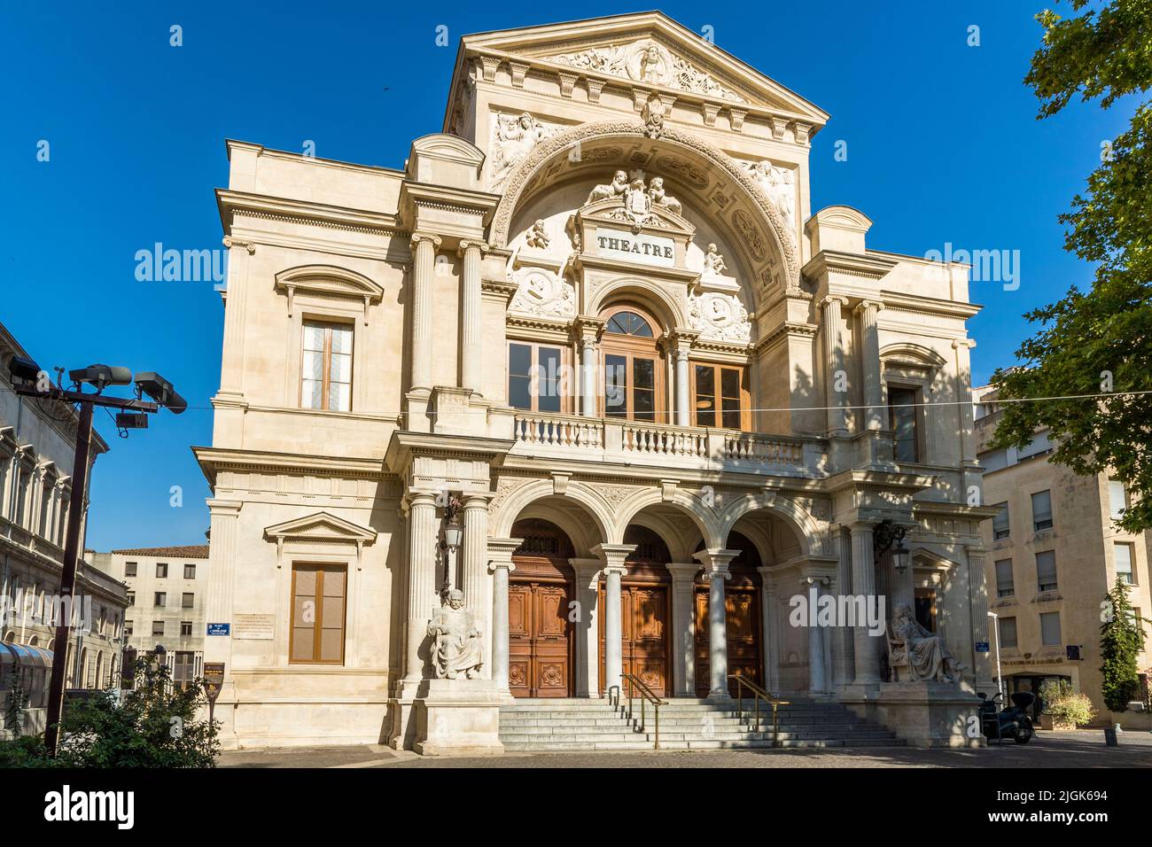 Il teatro di Avignone (Opéra Grand Avignon) in Place de l'Horloge porta la parola „Théâtre“ sopra il suo portale colonnato, Francia. Dopo che un incendio ha distrutto il precedente edificio, gli architetti Léon Feuchère e Théodore Charpentier hanno ricostruito l'attuale struttura nel 1846/47; è un monumento storico classificato dal 1988. Ristrutturato in modo esteso tra il 2017 e il 2020, funge anche da sede per l'annuale Festival teatrale di Avignone. Foto Stock