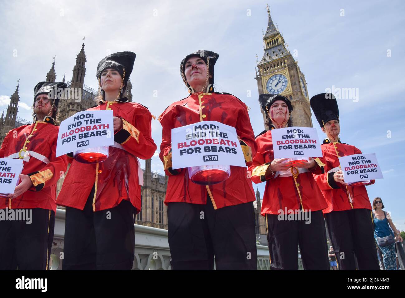 Londra, Inghilterra, Regno Unito. 11th luglio 2022. Gli attivisti DI PETA che indossavano i costumi della Queen's Guards, ricoperti di sangue falso e in piedi su Union Jacks macchiati di sangue, hanno organizzato una protesta contro l'uso di pelli di orso nei cappucci della Queen's Guards sul Ponte di Westminster fuori dal Parlamento. Attualmente, il Ministero della Difesa utilizza la vera pelliccia di orso per fare le calotte, e ci vuole un orso per fare solo una testa. PETA ha contribuito a sviluppare un'alternativa adatta alla pelliccia sintetica, che il MOD ha finora rifiutato di utilizzare. (Credit Image: © Vuk Valcic/ZUMA Press Wire) Foto Stock