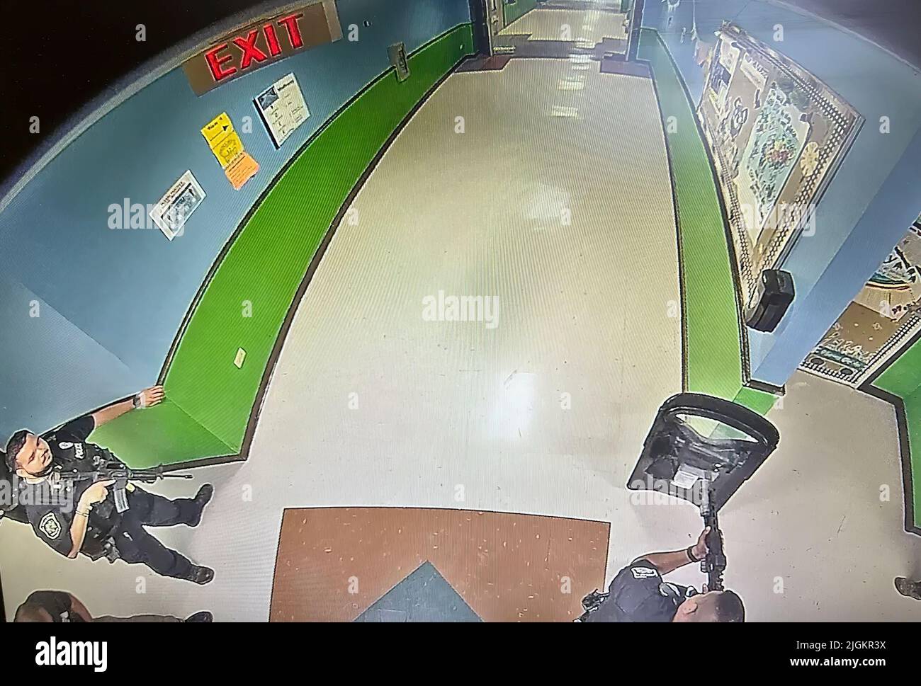 Una cornice di un video di sorveglianza della scuola mostra più poliziotti in attesa in un corridoio alla scuola elementare Robb armati di fucili e almeno uno scudo balistico protettivo. Questo è stato 19 minuti dopo aver ricevuto una chiamata 911 dalla scuola. La polizia ha aspettato quasi un'ora e mezza prima di entrare nella stanza della scuola dove si trovava il cannoniere. (Foto: Archivio investigativo di Uvalde) Foto Stock