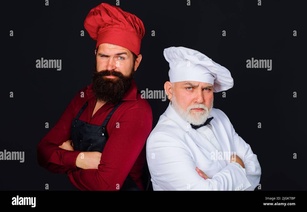 Cucina professionale. Chef del ristorante in uniforme che si levano in piedi l'uno all'altro. Concorso dello chef Foto Stock