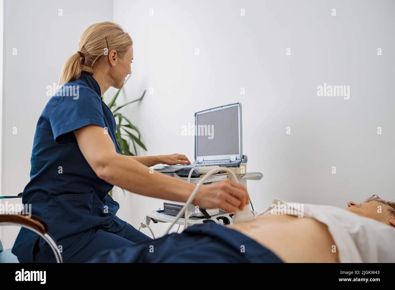 Medico ecografia esaminare paziente anziano addome in ospedale. Centro di diagnosi prenatale Foto Stock