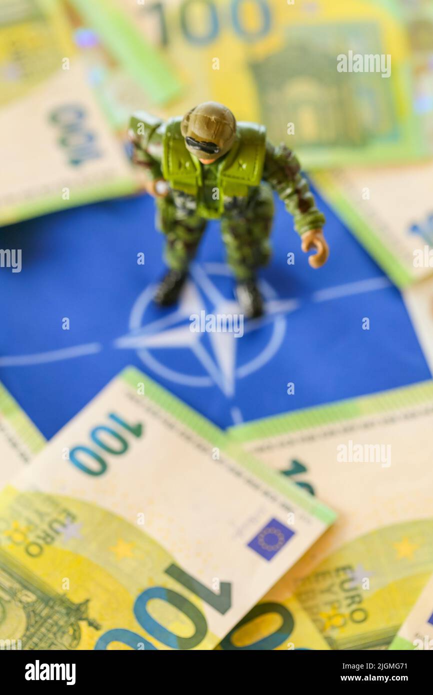 Finanziare la fornitura di armi, l'esercito in Europa.soldi per armamenti e truppe. Armi da fuoco decorative e fatture sulla bandiera dell'Unione europea. Foto Stock