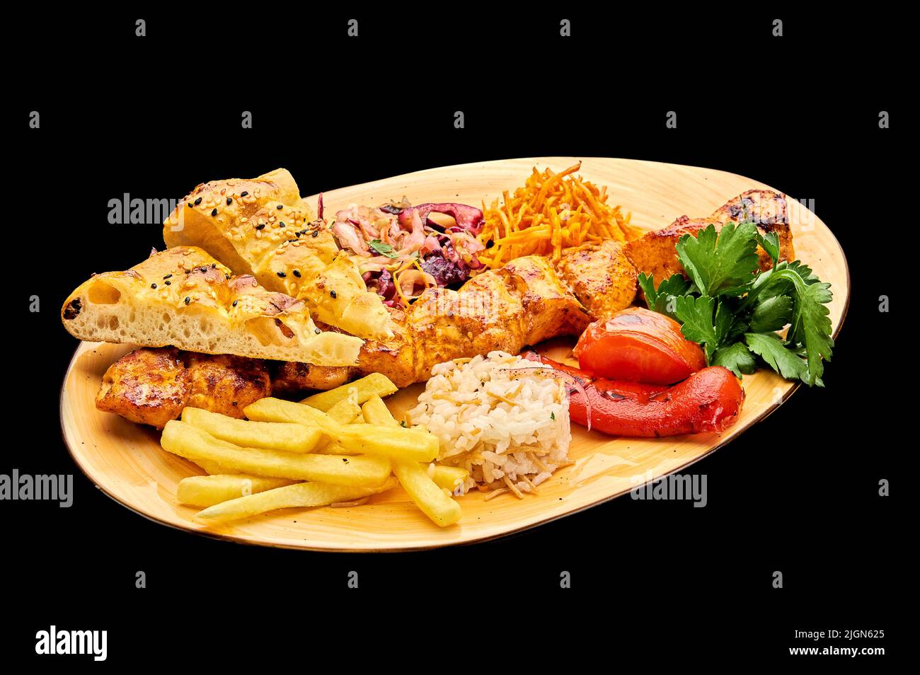 Il kebab succoso di filetto di pollo è disposto su un piatto con patatine fritte su uno sfondo nero isolato, Tavuk sew Foto Stock