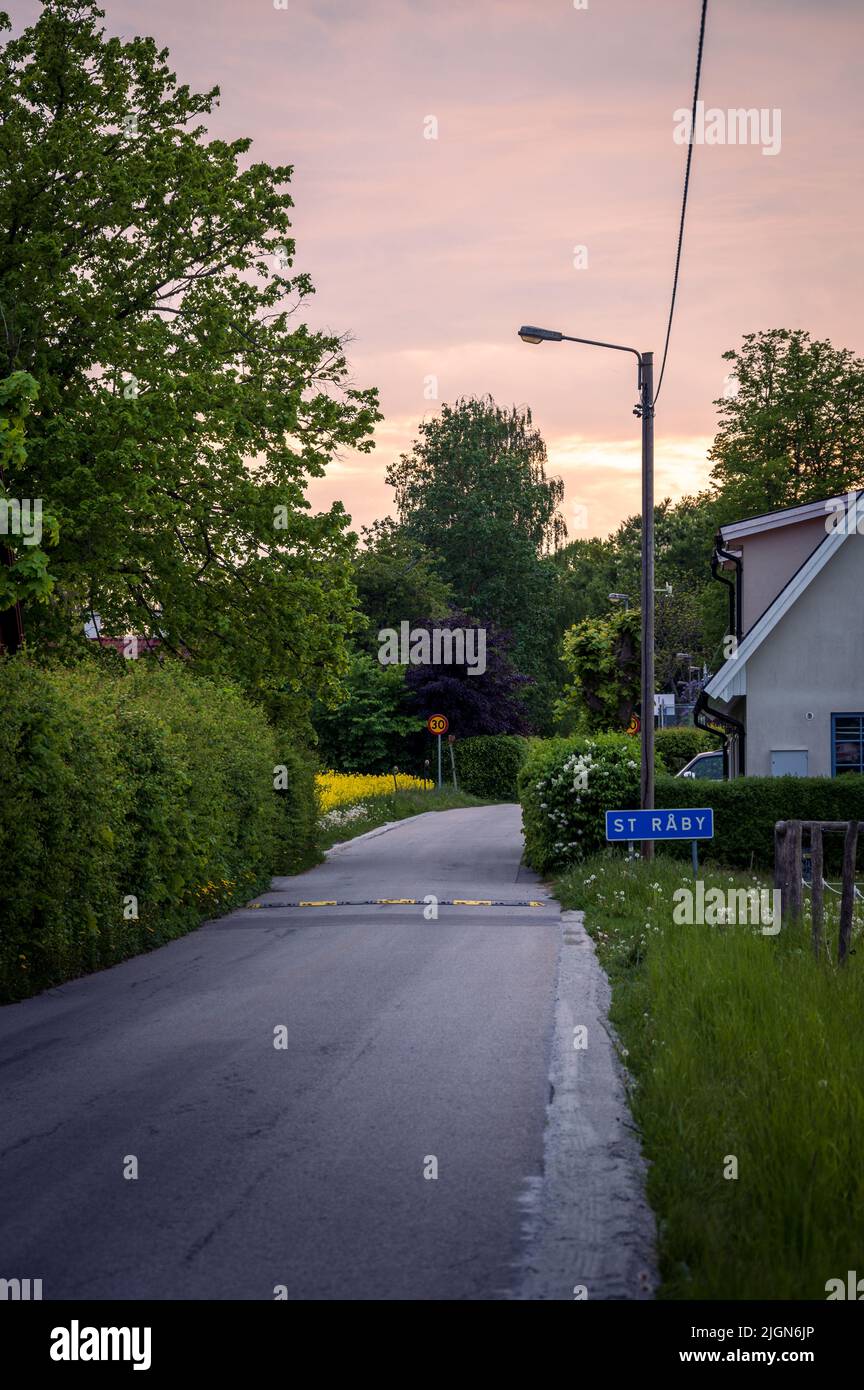 Strada rurale attraverso il villaggio di Stora Råby fuori Lund Svezia la sera d'estate Foto Stock