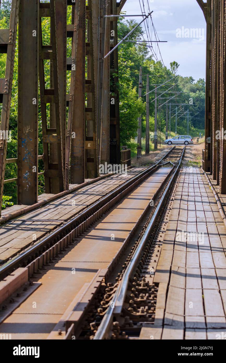 La struttura metallica del viadotto ferroviario sul fiume sullo sfondo di un cielo blu con nuvole. Giorno. Foto Stock