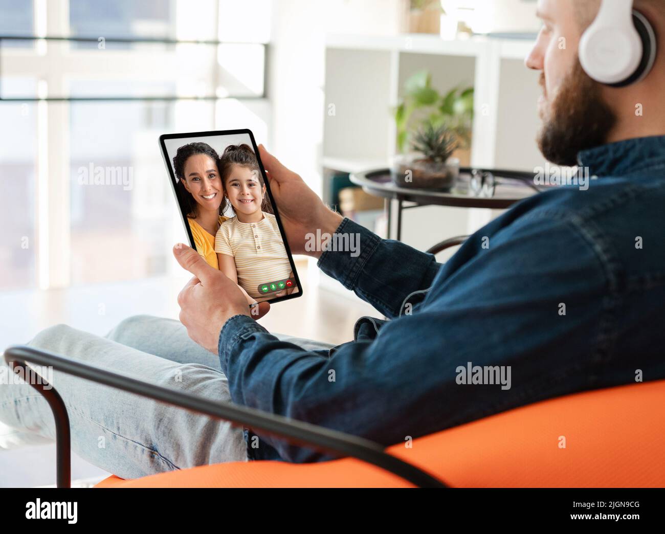 Uomo con tablet digitale che parla con moglie e figlia Foto Stock