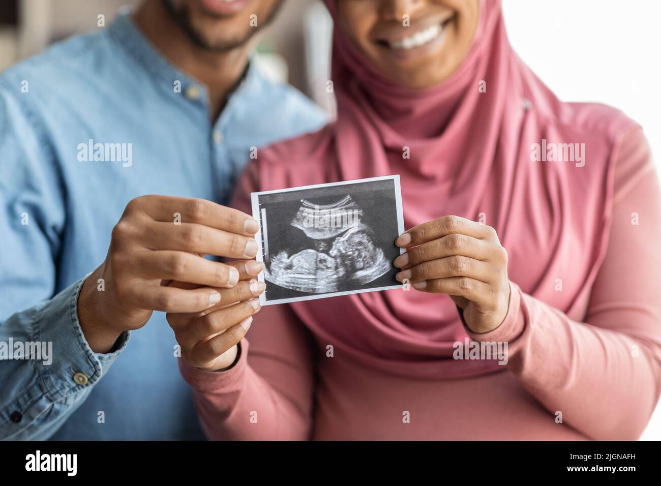 Buone spose mussulmane nere incinte che mostrano la foto della sonografia del bambino alla macchina fotografica Foto Stock