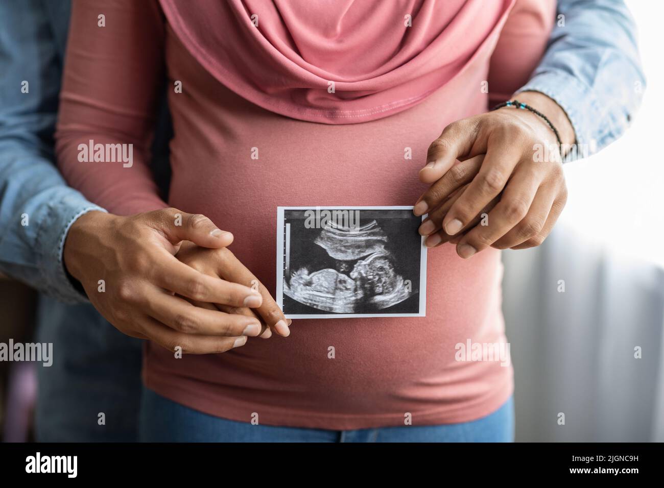 Donna musulmana incinta e suo marito che tiene il sonogramma del bambino immagine Foto Stock