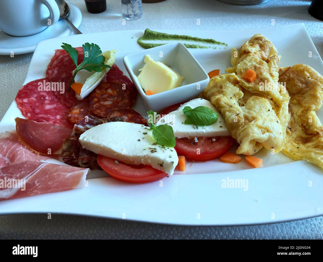 La colazione è un re. Delizioso pasto mattutino per iniziare la giornata. Uova strapazzate, lato soleggiato o frittata con sottili fette di pancetta di carne fredda, salame e prosciutto. Foto Stock