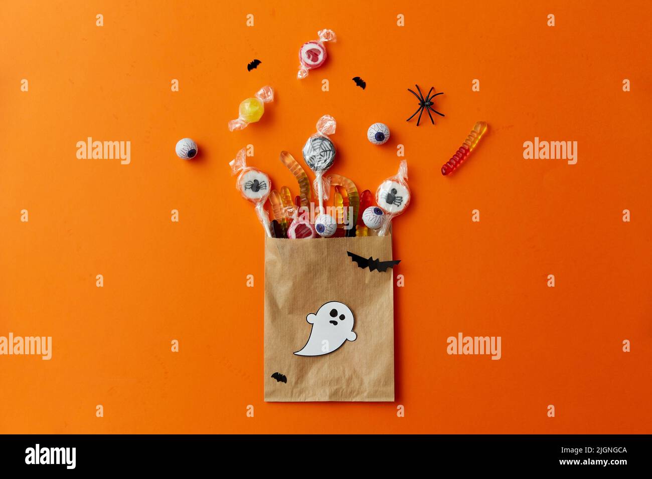 dolci di halloween in sacchetto di carta su sfondo arancione Foto Stock