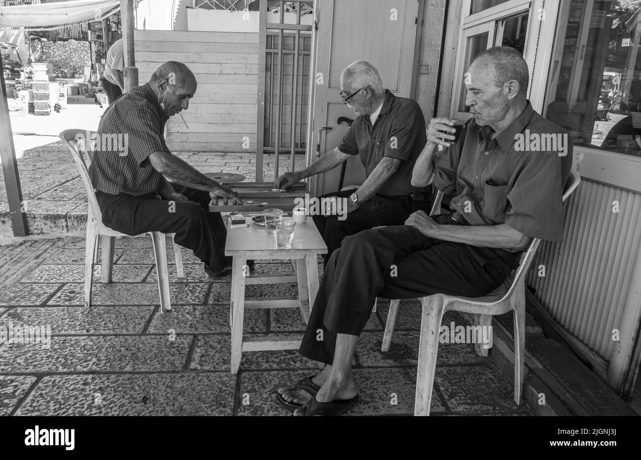 Uomini in un caffè che giocano backgammon nel mercato della Città Vecchia di Gerusalemme Foto Stock